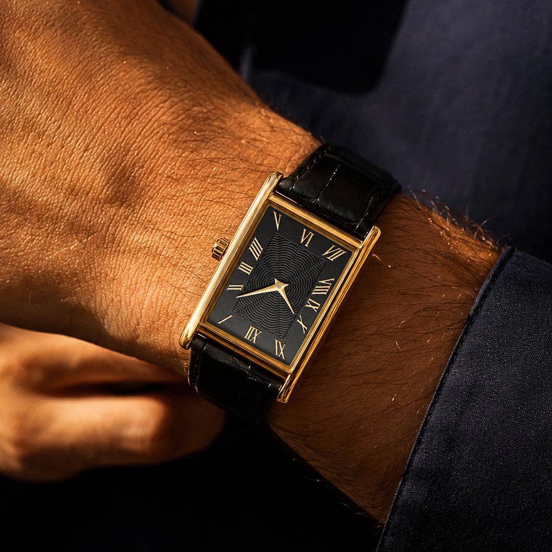 The 1962 gold tank watch on the wrist, black dial, worn with a navy shirt