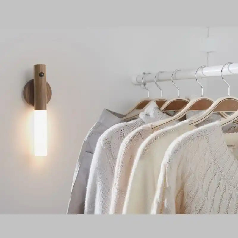 Rechargeable sensor wall light — illuminating hanging knitwear in a walk-in closet