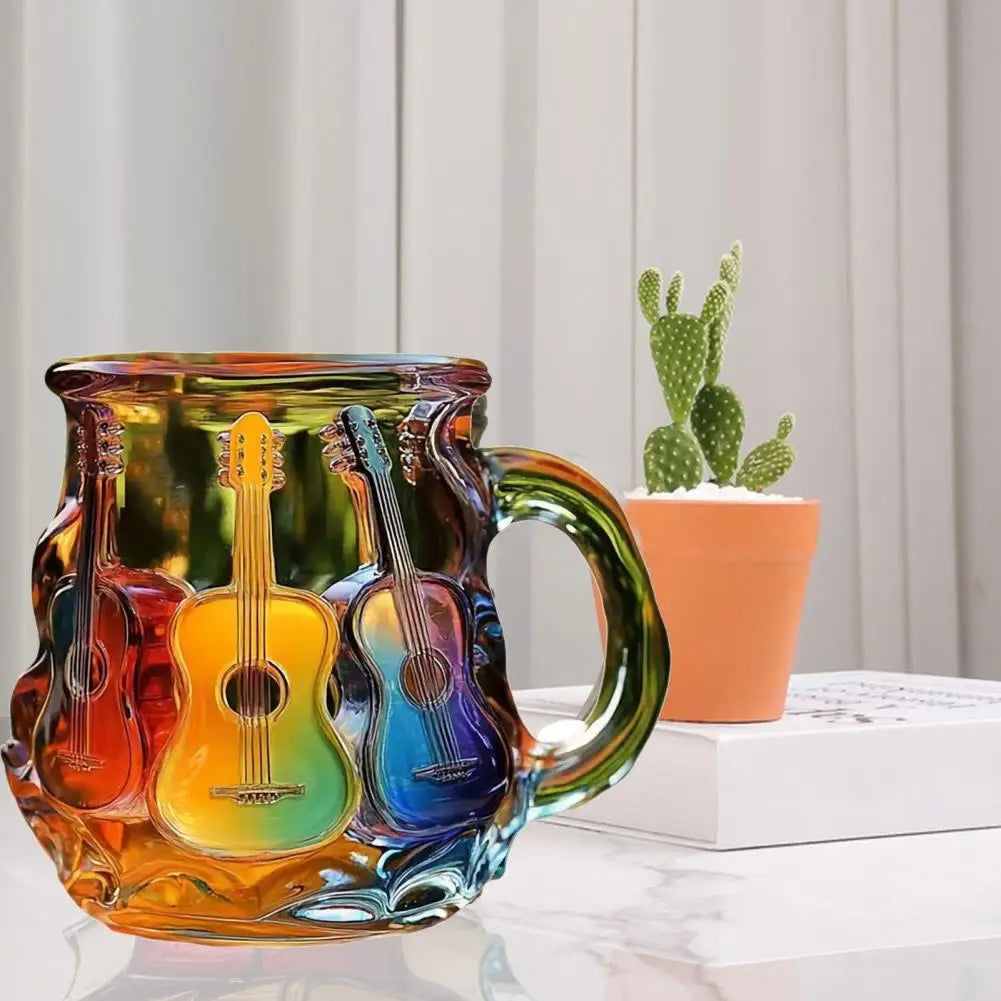 Colorful glass mug with guitar design on a desk with a potted plant in the background