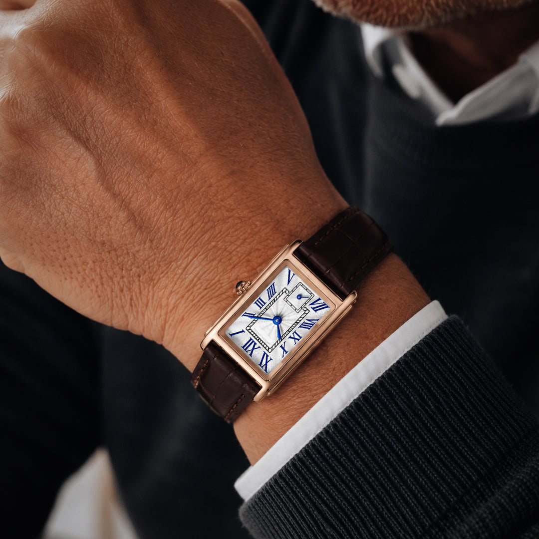 Close macro of the 1927 gold tank watch worn on the wrist, guilloche dial and blue Roman numerals